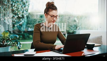 Telearbeit, Frau tippt auf Laptop zu Hause für Finanzbericht, externe Prüfung und Steuern. Freiberufler, Buchhalter und zufrieden mit Recherche zu Technologie Stockfoto