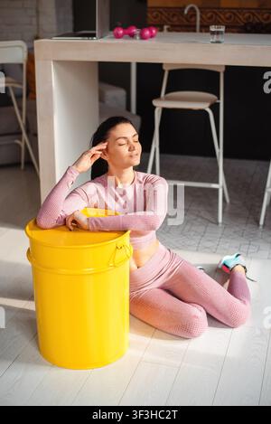 Junge Frau in Sportkleidung ruht nach dem Training zu Hause Stockfoto