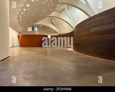 Ein Überblick über die Innengalerie des Guggenheim Museums Bilbao, der eine massive gebogene Wetterstahl-Skulptur aus Richard Serras The Matt zeigt Stockfoto