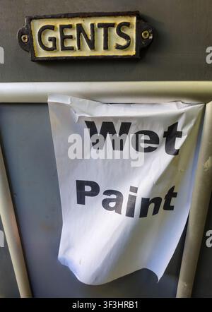 Ein amüsantes Schild in einer Herrentoilette mit der Aufschrift 'nasse Farbe', England, UK Stockfoto