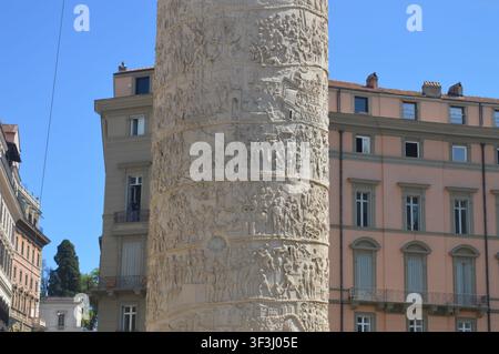 Ein sonniger Tagesblick auf die historische Trajanssäule neben der Kirche des Allerheiligsten Namens Maria im Trajanforum in Rom. Stockfoto