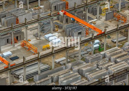 Luftbild der Produktion von großformatigen Stahlbetonplatten in einer industriellen Fabrikumgebung mit Kranen und Stapeln von Baumaterialien Stockfoto