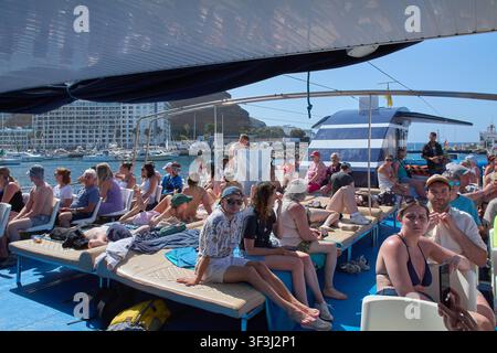 Puerto Rico, Spanien – 24. Juli 2026: Passagiere sonnenbadet und genießen eine Küstenbootfahrt entlang der malerischen felsigen Küste von Gran Canaria. Stockfoto