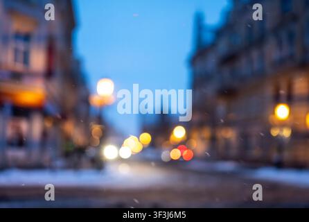 Unscharfes Foto einer Winterstraße am Abend mit Stadtlichtern Stockfoto