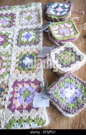 Arbeitsfortschritt-Häkelprojekt mit teilweise montierten Granny Squares. Handgemachter Patchwork-Prozess und kreatives Routinekonzept. Handwerksprozess, Hand Stockfoto