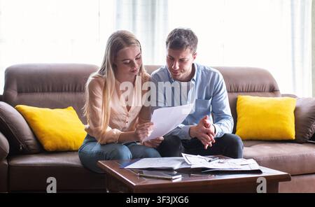 Junge verheiratete Paar suchen durch Mietvertrag im Haus zu verkaufen Stockfoto