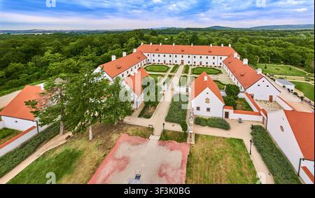 Luftaufnahme des historischen Majk-Komplexes, der das Kamaldulenserkloster und die Esterházy-Lodge zeigt, umgeben von üppiger Vegetation und formalen Gärten Stockfoto