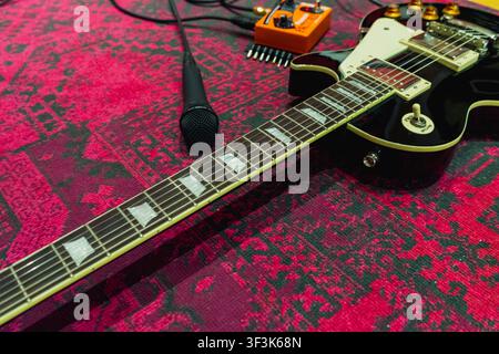 E-Gitarre und Mikrofon mit rotem Hintergrund Stockfoto
