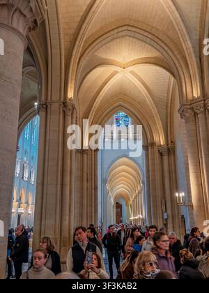 Menschen gehen durch das Hauptschiff der Kathedrale Notre-Dame de Paris unter neu restaurierten Gewölbedecken in Paris, Frankreich Stockfoto