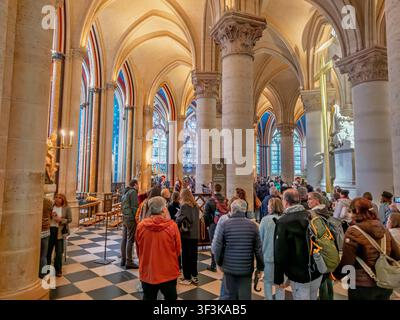 Menschen gehen durch das Hauptschiff der Kathedrale Notre-Dame de Paris unter neu restaurierten Gewölbedecken in Paris, Frankreich Stockfoto