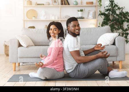 Fröhliche afrikanische erwartet Paar zusammen trainieren zu Hause Stockfoto