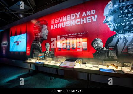 Ausstellung von Kennedy und Chruschtschow im Spionagemuseum | WASHINGTON D.C., Vereinigte Staaten — Eine wandgroße Grafik, die John F. Kennedy und Nikita Chruschtschow zeigt, dominiert die Galerie zur Kubakrise im Internationalen Spionagemuseum, datiert auf den 14. Oktober 1962 — den Tag, an dem US-Aufklärungsfotos sowjetische Raketen in Kuba bestätigten. Glasvitrinen darunter enthalten Artefakte, die mit Oleg Penkowski, dem sowjetischen Militärnachrichtendienstoffizier, verbunden sind, dessen geheime Berichte an die CIA und MI6 Kennedy halfen, Chruschtschows wahre Absichten während des Konflikts einzuschätzen. Stockfoto