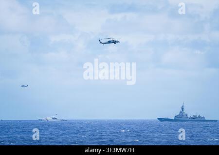 HMAS Sydney, ein Zerstörer der Klasse Hobart der Königlichen Australischen Marine, und BRP Gabriela Silang, ein Hochseepatrouillenboot der Klasse Gabriela Silang der Philippinischen Küstenwache, nehmen an der Gruppenregatta Rim of the Pacific 2026 teil, wobei zwei MH-60-Hubschrauber über ihnen fliegen, im Rahmen einer multinationalen Übung mit 30 Nationen und über 30.000 Teilnehmern. Stockfoto