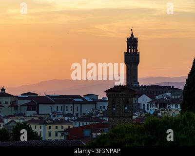Ein ruhiger Sonnenuntergang erhellt die historische Florenzer Skyline und wirft einen warmen goldenen Schimmer auf den ikonischen Turm des Palazzo Vecchio. Stockfoto