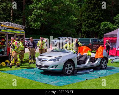 Notfalldienstmitarbeiter zeigen Fahrzeugrettungsfähigkeiten nach dem Entfernen eines Autodachs bei einer öffentlichen Demonstrationsveranstaltung. Stockfoto