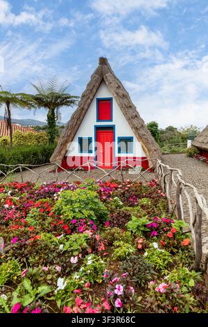 traditionelles farbenfrohes dreieckiges Strohdachhaus und Garten in Santana auf Madeira Stockfoto