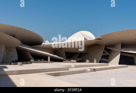 Doha, Katar - 14. Februar 2026: Außenansicht des Nationalmuseums von Katar, das moderne Architektur und einzigartige Steinskulpturen im Freien zeigt. Stockfoto