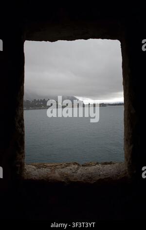 Blick über den Genfer See, eingerahmt von einem mittelalterlichen Fenster im Schloss Chillon, Montreux, Schweiz Stockfoto