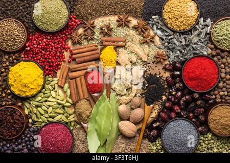 Buntes Gewürz- und Kräuter-Hintergrund. Großes Set Gewürze, die auf dem Tisch verstreut sind. Stockfoto