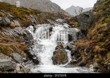 Alpenwasserfall stürzt über Felsen unter bewölktem Himmel im Hatcher Pass Palmer Alaska USA Stockfoto