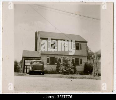 Zweistöckiger Bungalow im Kolonialstil mit kleiner Garage und einem Auto, das in der Einfahrt parkt, River Edge, New Jersey, ca. 1942. Gescannte Vintage-Fotografie aus dem Familienalbum. Stockfoto