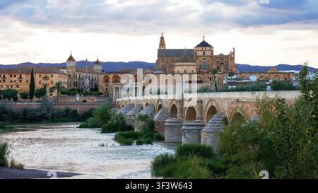 Panoramablick auf Cordoba, Spanien, mit der römischen Brücke über den Guadalquivir und der Skyline der Mezquita-Kathedrale bei Sonnenuntergang, die andalusische Atmosphäre zeigend Stockfoto