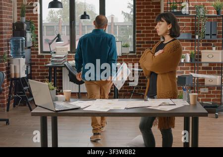 Wütender Büroangestellter wirft Diagrammpapiere nach einem Streit, zeigt Arbeitsplatzstress, Finanzdokumente und Geschäftsfrustration. Stockfoto