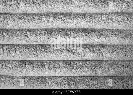 Weiche graue gestreifte, flauschige Stofftextur im Nahaufnahme-Hintergrund. Stockfoto