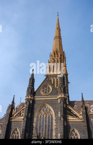 Melbourne, VIC, Australien. 21. Juli 2026. - Eine niedrig gehaltene Aufnahme des ikonischen gotischen Kathedralturms, der sich in Richtung des klaren, weiten blauen H Stockfoto