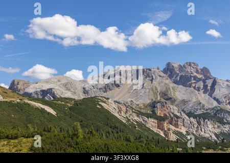 Lange weiße Wolken erstrecken sich über eine geformte Wand aus Kalkstein in Norditalien. Über das Sennes-Hochland gesehen, kombiniert die Kette blasse Regale, rotes C Stockfoto
