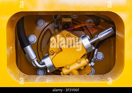 Nahaufnahme von industrieller hydraulischer Pumpe und Druckschlauchsystem schwerer gelber Baumaschinen Stockfoto