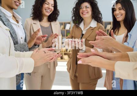 Vielfältige Geschäftsfrauen applaudieren während eines Workshops im Büro und feiern Erfolg Stockfoto