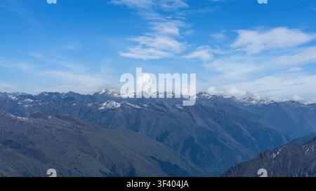 Panoramatische Ansicht einer schneebedeckten Bergkette vor blauem Himmelhintergrund Stockfoto
