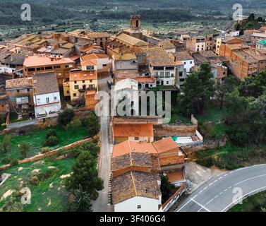 Luftbild eines kleinen Dorfes mit Terracotta-Dächern in der Nähe von Margalef, Katalonien, Spanien, eingebettet zwischen grünen Hügeln und Olivenbäumen. Eine charmante ländliche Siedlung Stockfoto