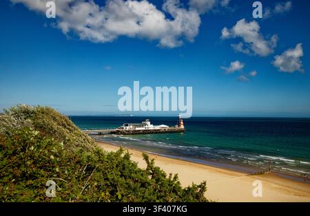 Ein Meerespier ragt in ein tiefblaues Meer unter einem fast wolkenlosen blauen Himmel, Bournemouth, Dorset, England. Stockfoto