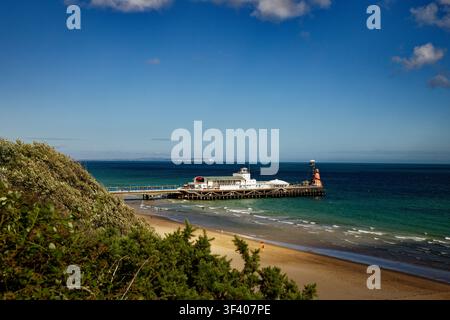 Ein Meerespier ragt in ein tiefblaues Meer unter einem fast wolkenlosen blauen Himmel, Bournemouth, Dorset, England. Stockfoto