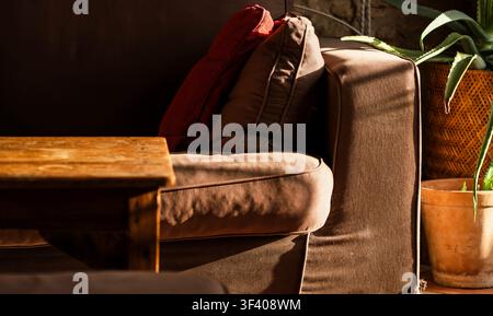 Inneneinrichtung in einem Vintage-Haus, ein gemütliches Sofa und ein Holztisch im Detail.. Stockfoto