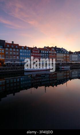 Beruhigendes Panorama des Kopenhagener Hafens mit gespiegelten Fassaden in der Ruhe des Sonnenaufgangs Stockfoto