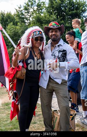 LONDON, UK - 26. JULI 2025: Menschen in festlichen Outfits und Federkopfschmuck feiern karibische Kultur beim Notting Hill Carnival. Stockfoto