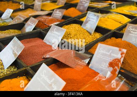Verschiedene farbenfrohe Gewürze und Gewürzmischungen, die in Holzschalen auf einem Markt in Arles, Frankreich, ausgestellt sind. Stockfoto