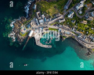 Luftaufnahme von oben des Dorfes und des Hafens von Coverack in Cornwall, UK, einem beliebten Sommerurlaubsziel für Urlauber bei Sonnenaufgang Stockfoto