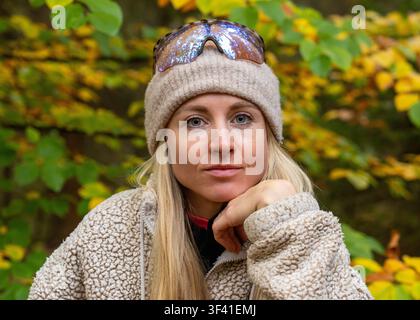 Porträt einer jungen Frau mit gestrickter Mütze, warmem Pullover in einem Herbstwald. Saisonale Mode, Outdoor-Lebensstil, Natur, Entspannung. Stockfoto
