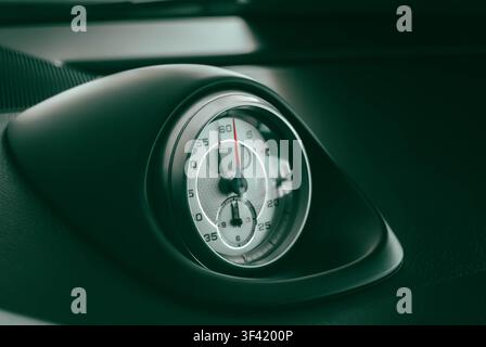 Nahaufnahme des analogen Sport-Chrono-Stoppuhren-Timers, der in das Lederarmaturenbrett eines Luxus-Porsche-Sportwagens integriert ist Stockfoto