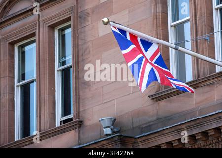 Union-Jack-Flagge auf einem Mast vor einem Gebäude Stockfoto