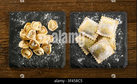 Frische italienische Cappelletti und Ravioli-Pasta auf Schiefer Tellern, bereit zum Kochen Stockfoto