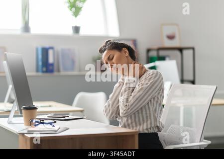 Leidende schwarze Frau, die im Büro ihren Hals berührt, Schmerzen erlebt, Geschäftskonzept Stockfoto