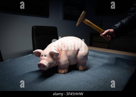 Ein Sparschwein soll mit einem Hammer zerschlagen werden. *** Ein Sparschwein soll mit einem Hammer zerschlagen werden  DATUM DES AUFNAHMES NICHTIGANGEBEN Stockfoto