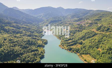 Hohe Luftaufnahme eines ruhigen türkisfarbenen Flusses, der durch ein üppiges grünes Bergtal in Richtung des Plastiras-Stausees in Karditsa Thessalien Griechenland fließt, für Reise Stockfoto