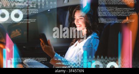 Zufriedene asiatische Frau, die im Auto ein Smartphone benutzt, engagiert und lächelnd, Technologie-Konzept Stockfoto