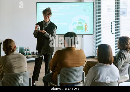 Junge erwachsene Frau präsentiert Nahrungsergänzungsmittel während einer geschäftlichen Schulung Stockfoto